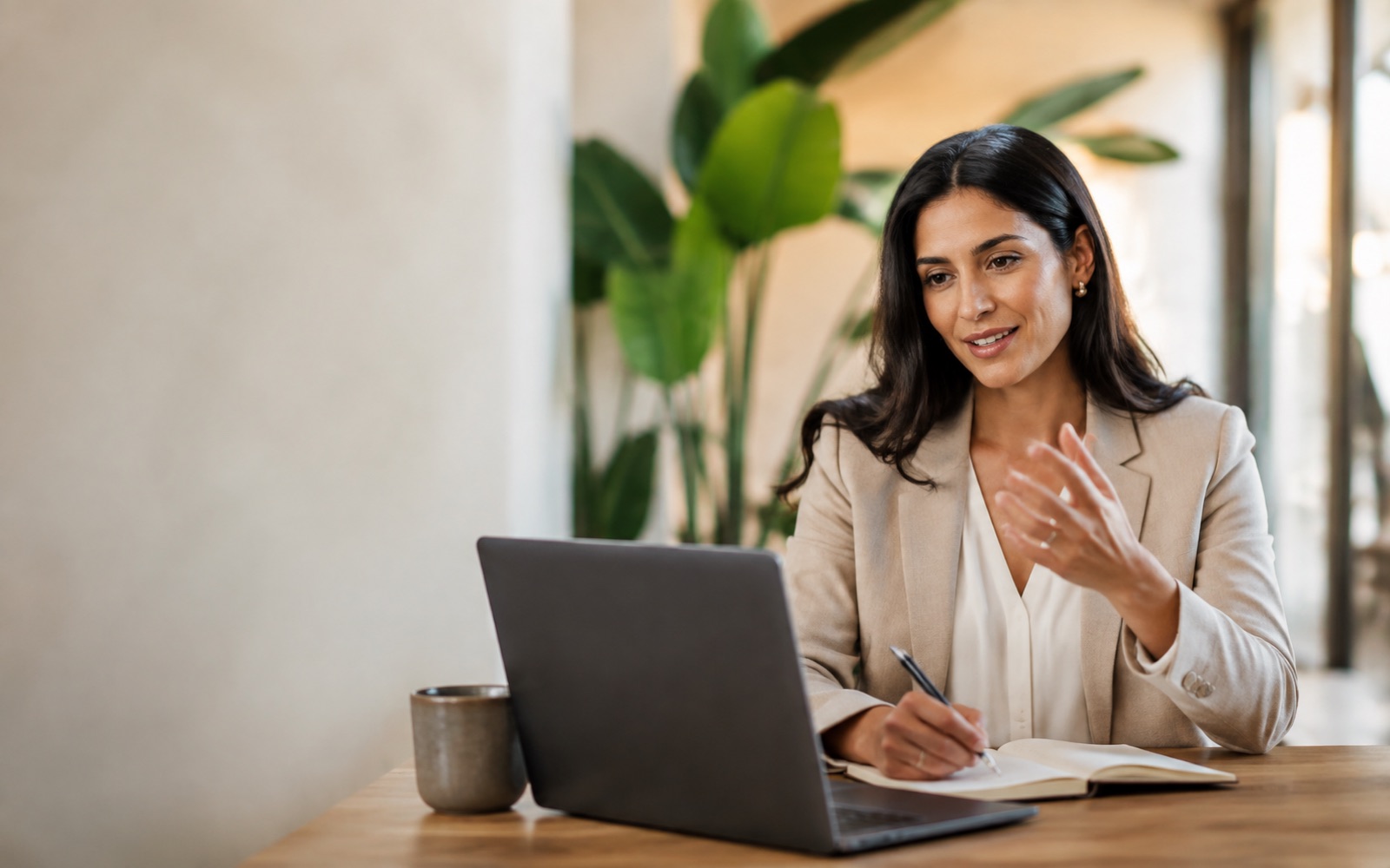 Ejecutiva comercial conversa con un cliente desde su notebook
